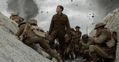 George MacKay stands as Lance Corporal Schofield in a World War I trench.